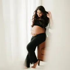 A stylish and relaxed solo portrait. A simple black outfit and soft window light are all that's needed to create a beautiful and modern maternity photo.