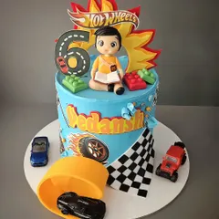 A revved-up Hot Wheels theme cake for Vedansh. This blueberry cake features a race track, Lego blocks, and a miniature of the birthday boy himself with his favorite book.