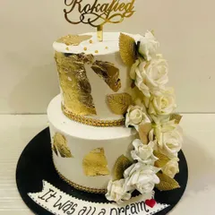 "It was all a Dream." A beautiful two-tiered white and gold cake for a "Rokafied" couple, featuring a cascade of white sugar roses and gold leaves.