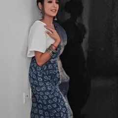A full-length shot showing how the simple bun hairstyle works beautifully with the traditional saree and accessories.