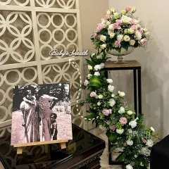 A beautiful corner from the golden jubilee celebration, featuring a vintage photo of the couple on an easel next to a cascading floral arrangement. It’s about honoring the journey.
