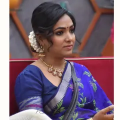 A close-up of Anupama Gowda, showcasing the elegant puff-sleeve blouse and traditional jewelry that complete her look.