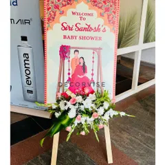 This is a personalized welcome board we designed for Siri and Santosh's baby shower. The custom illustration and elegant floral arrangement at the base create a warm and personal greeting for all the guests.