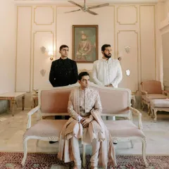 A regal portrait of the groom, Shubham, seated, flanked by his groomsmen, exuding an aura of classic royalty.