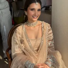 A seated portrait showing the full effect of her stunning pastel outfit. The makeup is kept clean and luminous, with a simple pearl choker and maang tikka completing the elegant look.