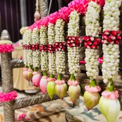 A close-up view of the detailed floral work on a cradle. Notice the fresh jasmine, pink flowers, and delicate lotus buds used to create these beautiful hanging garlands.