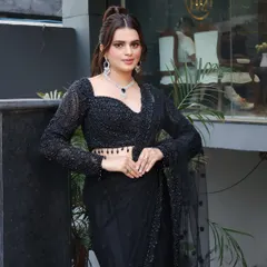 A classic black saree paired with a glamorous high ponytail and striking makeup. This look is all about elegance, with a bold lip and defined eyes.