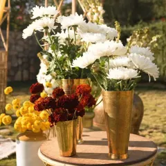 Brass vases are an elegant choice for Haldi function centerpieces. Here, I've used a mix of white chrysanthemums and red and yellow marigolds to create a beautiful, traditional arrangement.