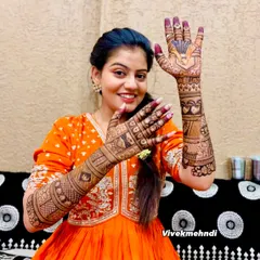 A happy bride proudly showing off her intricate full-arm mehndi. Her joy is what makes this art so special.
