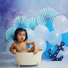 A simple and sweet bathtub session with a blue nautical theme. The anchor prop and blue balloons create a fun, sky-and-sea vibe for this little splasher.