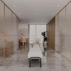 The clinic's hallway is designed for tranquility. Frosted glass panels with brass inlays provide privacy while allowing light to filter through. The clean lines and minimalist benches create a serene passage for patients.