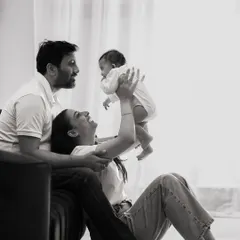 Sometimes, the most powerful moments are the quiet ones. This black and white photograph of new parents admiring their baby focuses on pure emotion and the beginning of their family story.