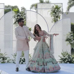 The couple shares a dance on their engagement day. The modern, all-white stage adorned with fresh flowers provides a stunning, minimalist backdrop.