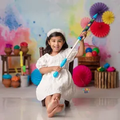 Ready for a splash of color! This little girl is all smiles and ready for fun in our vibrant and playful Holi-themed studio setup.