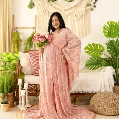 The pure joy of motherhood shines in this portrait. The mom-to-be looks radiant in a pink lace gown from our collection, set against our popular boho backdrop.