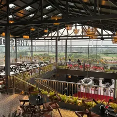 For 'The Soda Factory' pub in Mandya, we designed a multi-level green experience. This view shows how we integrated planters and greenery throughout the industrial-style space, enhancing the ambiance and offering patrons a view of the surrounding landscape.