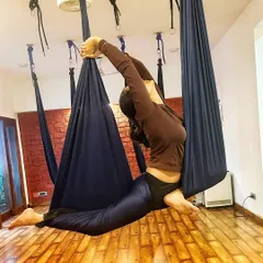 Another angle of the aerial backbend, highlighting the grace and strength involved. This pose helps open the heart and shoulders.