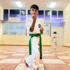 A young student demonstrates a strong Neko Ashi Dachi (cat stance), a fundamental posture in karate that builds balance and readiness.