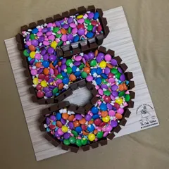 A classic for any chocolate lover, this number 5 cake features a KitKat border holding in a sea of colorful Gems. It's a fun, crunchy, and delicious centerpiece that's always a hit at children's parties.