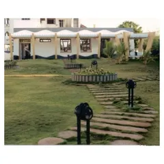 The landscaped garden of the CC Office in Tuticorin, featuring a stone pathway and a central planter. We designed the outdoor space as an extension of the building, creating a cohesive environment where architecture and landscape are one.