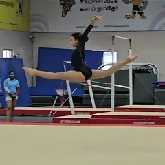 A perfect split leap from Oceana during her state-level competition. This shot captures the incredible flexibility and technique that our coaches help develop.