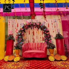 Your Mehndi should be as vibrant as you are. I created this fun and festive seating area with a plush pink sofa under a colorful floral arch, complete with hanging tassels and traditional marigold bowls for that perfect photo op.