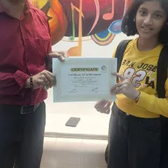 A proud moment as a student receives her certificate of achievement. We believe in formally recognizing the hard work and progress of every member of our academy.