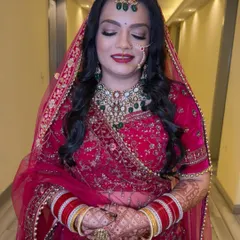 The soft glam on the eyes perfectly balances the bold red lip and traditional attire. This look is all about enhancing her features while keeping the focus on her.