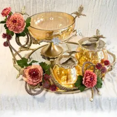 Luxury is found in the details. I have designed this amber glass and brass collection to bring a regal warmth to your home. Each piece, from the floral-adorned tray to the lidded jars, is crafted to be a timeless centerpiece for your celebrations.
