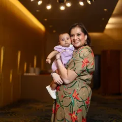 A mother holding her baby in a beautifully lit hallway. This is a simple, elegant portrait that focuses on the bond between them.