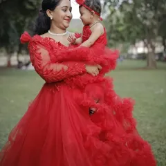 I love creating matching outfits for the whole family. This mother-daughter combo in vibrant red features a layered ruffle gown for mom and a perfectly coordinated frock for the little one, ideal for birthdays and special photoshoots.