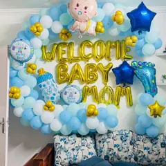 A 'Welcome Baby Mom' wall decoration with a cloud of blue and white balloons and lots of cute, baby-themed foil balloons.
