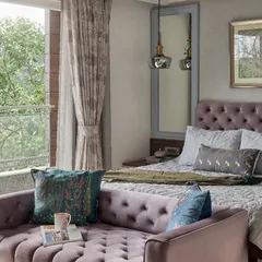 This master bedroom at The Classic Modern Storey balances serenity with subtle energy using tones of lavender and teal. The tufted classical-style bed and multifunctional daybed offer versatility, while a large mirror reflects the outdoor views, integrating nature into the room.