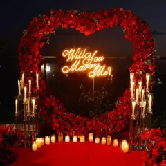 For a truly unforgettable proposal, I create dramatic and romantic backdrops like this one. A heart-shaped arch of red roses, a neon "Will You Marry Me?" sign, and dozens of candles create the perfect atmosphere for a yes.