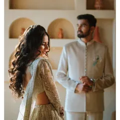 A candid-style portrait with beautiful indoor lighting. The bride looks back at the groom with a smile, creating a natural and intimate moment that feels both spontaneous and elegant.