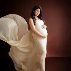 Twirling into motherhood. I love using flowing fabrics to add movement and grace to my portraits, like in this shot with a beautiful off-white gown against a solid backdrop.