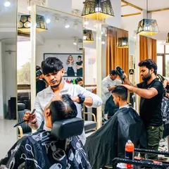 A busy day at the salon with multiple clients getting groomed. In the foreground, a client is getting a precise shave, showing the range of men's grooming services we offer.