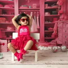 It's a Barbie world, and this little one owns it. My Barbie-themed shoots are all about capturing that fun, confident personality with a vibrant pink set and stylish props like these heart-shaped sunglasses.