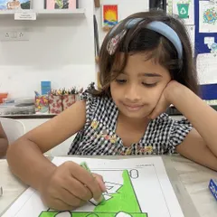 A young artist is completely absorbed in her work, carefully coloring with oil pastels. Our classes provide a calm and focused environment where children can concentrate and let their creativity flow at their own pace.