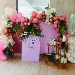 Celebrating a 60th birthday calls for elegance. For this event, I designed a sophisticated photo booth with a soft lilac arch panel, framed by a lush balloon garland in shades of dusty rose, pink, and white, accented with fresh greenery for a touch of natural beauty.