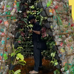 The installation was built in just six days, showing the contrast between a wall of plastic waste on the outside and a sanctuary of living plants on the inside.