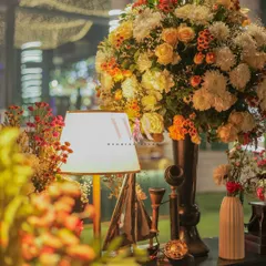 The soft glow of a table lamp illuminates a beautiful floral arrangement and a collection of vintage props. I love creating these small, interesting corners that invite guests to look closer.