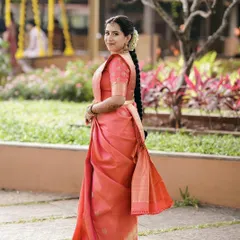 A full-length view showcasing the elegant saree drape and the traditional braided hairstyle adorned with fresh flowers, completing Ruchira's muhurtha look.