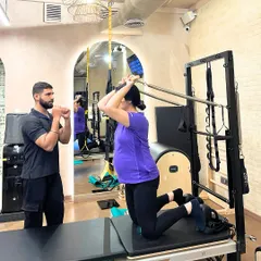 Prenatal Pilates includes gentle arm work on the tower to maintain upper body strength, which is essential for motherhood.