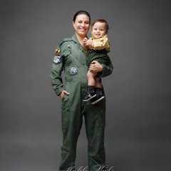 A powerful portrait of a mother in her Airforce uniform holding her child. It's a beautiful blend of her roles as a pilot and a loving mom.