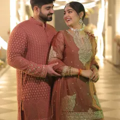 For our Sundarkand Path, we chose a deeper, rustier shade of orange. His kurta's intricate pattern subtly picks up the tones in my embroidered sharara suit, making our look feel connected and thoughtful.