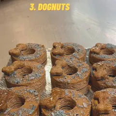 My dognuts are a party favorite. These are topped with a peanut butter-based frosting, coconut sprinkles, and a small biscuit for an extra crunch.