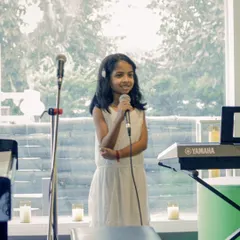A young vocalist confidently taking the stage at our student recital. We provide a safe and encouraging environment for our youngest performers to shine.