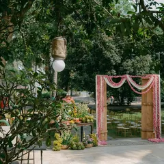 A wide shot of the outdoor venue, showing the floral archway in the distance and other decor elements that create a welcoming atmosphere.