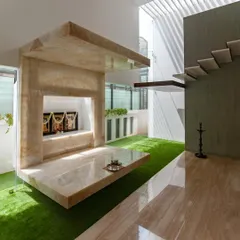 A floating pooja room crafted from a single volume of backlit onyx. Positioned directly under a skylight, the space is designed to be a tranquil core within the home, glowing with natural and integrated light.